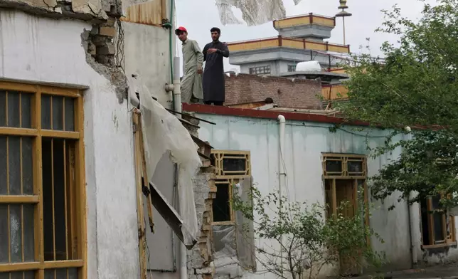 Residents inspect a building damaged by heavy flooding in Jalalabad, Afghanistan, Saturday, April 4, 2026. (AP Photo/Wahidullah Kakar)