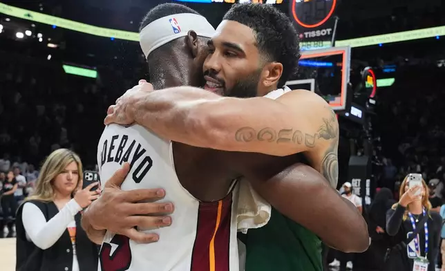 Miami Heat center Bam Adebayo (13) and Boston Celtics forward Jayson Tatum, right, embrace after an NBA basketball game, Wednesday, April 1, 2026, in Miami. (AP Photo/Lynne Sladky)