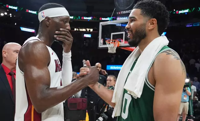 Miami Heat center Bam Adebayo, left, and Boston Celtics forward Jayson Tatum, right, shake hands after an NBA basketball game, Wednesday, April 1, 2026, in Miami. (AP Photo/Lynne Sladky)