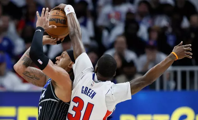 Orlando Magic forward Paolo Banchero (5) has his shot blocked by Detroit Pistons guard Javonte Green (31) during the first half in Game 2 of a first-round NBA basketball playoffs series Wednesday, April 22, 2026, in Detroit. (AP Photo/Duane Burleson)