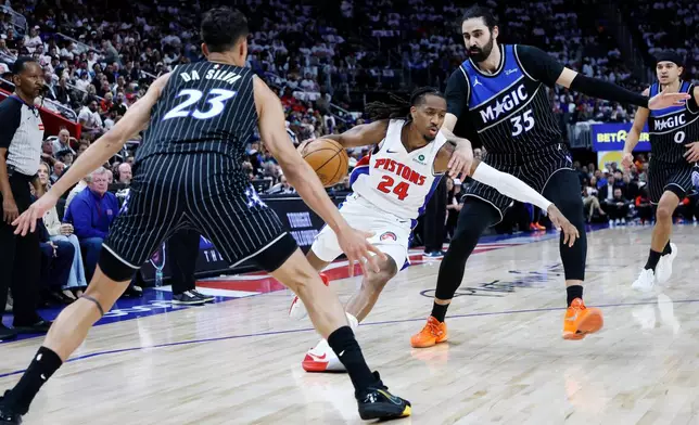 Detroit Pistons guard Daniss Jenkins (24) drives to the basket against Orlando Magic forward Tristan da Silva (23) and center Goga Bitadze (35) during the first half in Game 2 of a first-round NBA basketball playoffs series Wednesday, April 22, 2026, in Detroit. (AP Photo/Duane Burleson)