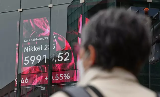 A person stands in front of an electronic stock board showing Japan's Nikkei index at a securities firm Thursday, April 23, 2026, in Tokyo. (AP Photo/Eugene Hoshiko)
