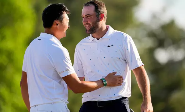 Haotong Li, of China, greets Scottie Scheffler after their final round of the Masters golf tournament at the Augusta National Golf Club, Sunday, April 12, 2026, in Augusta, Ga. (AP Photo/David J. Phillip)