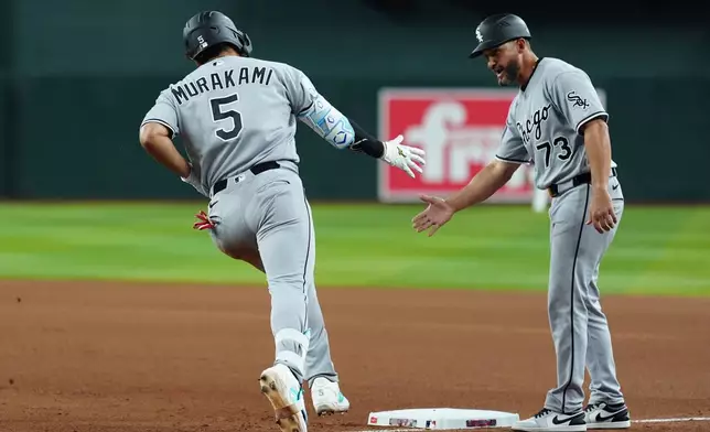 Chicago White Sox's Munetaka Murakami (5), of Japan, celebrates his two-run home run against the Arizona Diamondbacks with White Sox third base coach Jose Leger (73) during the seventh inning of a baseball game, Wednesday, April 22, 2026, in Phoenix. (AP Photo/Ross D. Franklin)