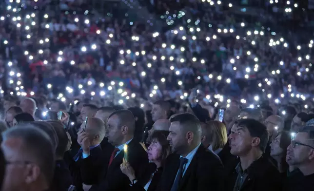 Supporters of former Bulgarian President Rumen Radev hold phone lights during the closing rally of his campaign in Sofia, Thursday, April 16, 2026, as Bulgaria heads into an early parliamentary election. (AP Photo/Valentina Petrova)