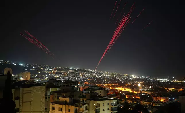 Tracer rounds illuminate the night sky as people fire live ammunition and fireworks into the air following a ceasefire between Israel and Hezbollah, in Beirut, Lebanon, early Friday, April 17, 2026. (AP Photo/Hassan Ammar)