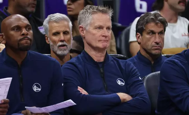 Golden State Warriors head coach Steve Kerr, right, looks on from the bench during the first half of an NBA basketball game against the Sacramento Kings, Friday, April 10, 2026, in Sacramento, Calif. (AP Photo/Scott Marshall)