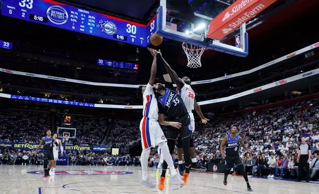 Detroit Pistons guard Ausar Thompson (9) and forward Isaiah Stewart (28) defend against a shot Orlando Magic center Goga Bitadze (35) during the first half in Game 2 of a first-round NBA basketball playoffs series Wednesday, April 22, 2026, in Detroit. (AP Photo/Duane Burleson)