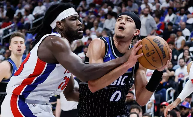 Orlando Magic guard Anthony Black (0) is fouled by Detroit Pistons forward Isaiah Stewart (28) while driving to the basket during the second half in Game 2 of a first-round NBA basketball playoffs series Wednesday, April 22, 2026, in Detroit. (AP Photo/Duane Burleson)
