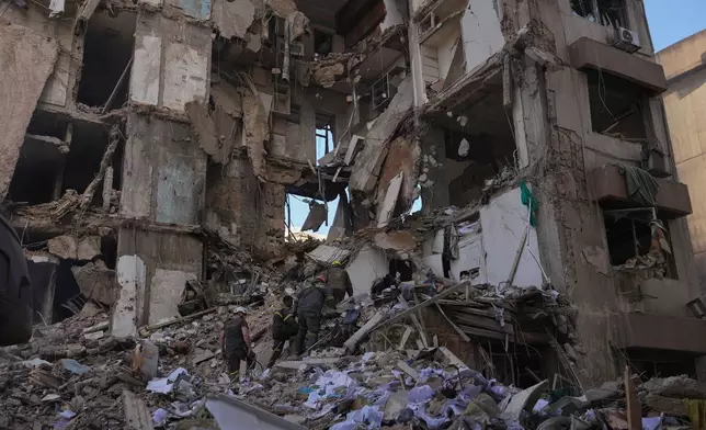 Lebanese civil defense workers search for victims in the rubble of a building destroyed in an Israeli airstrike a day earlier in central Beirut, Lebanon, Thursday, April 9, 2026. (AP Photo/Hassan Ammar)