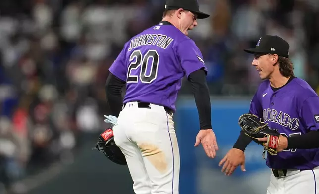 Colorado Rockies first baseman Troy Johnston, left, celebrates with left fielder Jordan Beck after defeasting the Los Angeles Dodgers in a baseball game Saturday, April 18, 2026, in Denver. (AP Photo/David Zalubowski)
