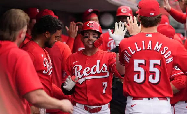 Cincinnati Reds' Spencer Steer, center, is congratulated in the dugout after hitting a two-run home run during the first inning of a baseball game, Tuesday, April 28, 2026, in Cincinnati. (AP Photo/Kareem Elgazzar)