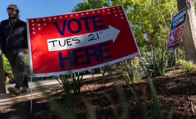 A person walks to vote in the Virginia redistricting referendum at Lyles-Crouch Traditional Academy, Tuesday, April 21, 2026, in Alexandria, Va. (AP Photo/Julia Demaree Nikhinson)