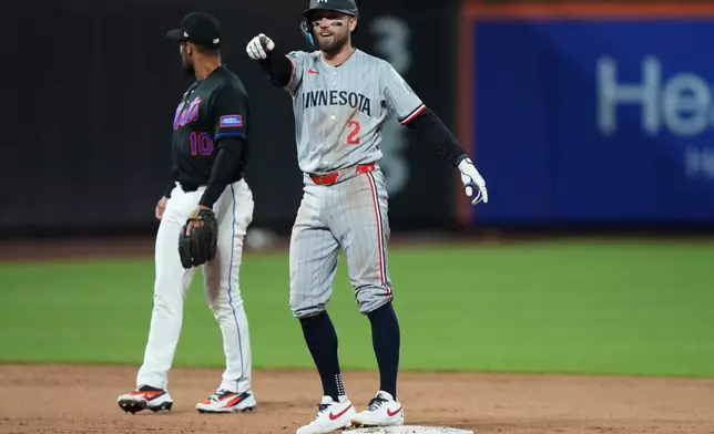 Minnesota Twins' Kody Clemens (2) gestures to Luke Keaschall after Keaschall hit an RBI single during the ninth inning of a baseball game against the New York Mets Tuesday, April 21, 2026, in New York. (AP Photo/Frank Franklin II)