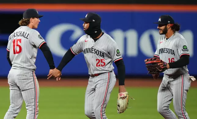 Minnesota Twins' Luke Keaschall (15) celebrates with teammates Byron Buxton (25) andn Austin Martin (16) after a baseball game against the New York Mets Tuesday, April 21, 2026, in New York. (AP Photo/Frank Franklin II)