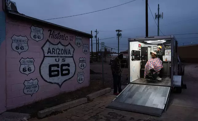 Rana Bal gets a haircut from Daniel Bailon inside a mobile barbershop in Holbrook, Ariz., a town on historic Route 66, Wednesday, Nov. 19, 2025. (AP Photo/Jae C. Hong)