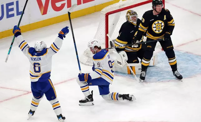 Buffalo Sabres' Josh Doan (91) celebrates his goal with Zach Benson (6) beside Boston Bruins' Jeremy Swayman (1) and Charlie McAvoy (73) during the first period in Game 4 of a first-round NHL hockey Stanley Cup playoff series, Sunday, April 26, 2026, in Boston. (AP Photo/Michael Dwyer)