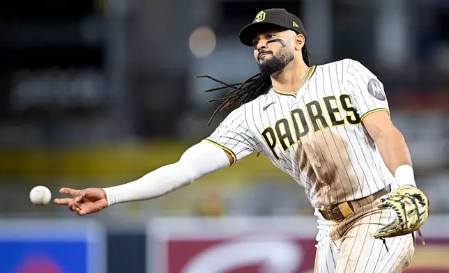 San Diego Padres second baseman Fernando Tatis Jr. (23) throws out Colorado Rockies' Troy Johnston (20) at first base during the sixth inning of a baseball game Saturday, April 11, 2026, in San Diego. (AP Photo/Denis Poroy)