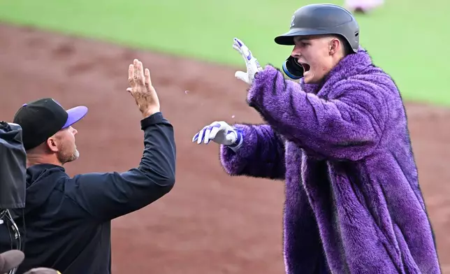 Colorado Rockies' Mickey Moniak, right, is congratulated by manager Warren Schaeffer after hitting a two-run home run during the first inning of a baseball game against the San Diego Padres Saturday, April 11, 2026, in San Diego. (AP Photo/Denis Poroy)