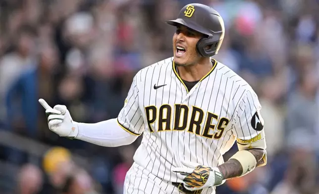 San Diego Padres' Manny Machado (13) celebrates after hitting a two-run home run during the third inning of a baseball game against the Colorado Rockies Saturday, April 11, 2026, in San Diego. (AP Photo/Denis Poroy)