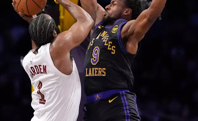 Cleveland Cavaliers guard James Harden, left, shoots as Los Angeles Lakers guard Bronny James defends during the first half of an NBA basketball game Tuesday, March 31, 2026, in Los Angeles. (AP Photo/Mark J. Terrill)