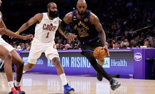 Los Angeles Lakers forward LeBron James, right, drives by Cleveland Cavaliers guard James Harden during the first half of an NBA basketball game Tuesday, March 31, 2026, in Los Angeles. (AP Photo/Mark J. Terrill)