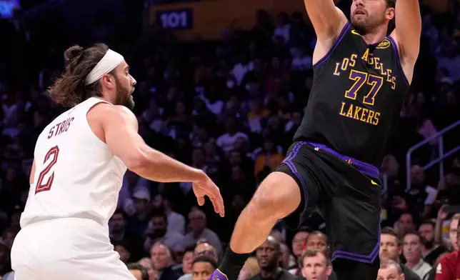 Los Angeles Lakers guard Luka Doncic, right, shoots as Cleveland Cavaliers guard Max Strus defends during the first half of an NBA basketball game Tuesday, March 31, 2026, in Los Angeles. (AP Photo/Mark J. Terrill)