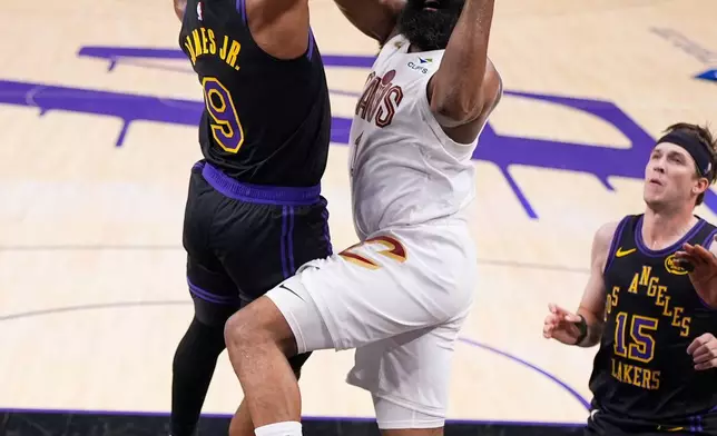 Cleveland Cavaliers guard James Harden, center, shoots as Los Angeles Lakers guard Bronny James, left, and guard Austin Reaves defend during the first half of an NBA basketball game Tuesday, March 31, 2026, in Los Angeles. (AP Photo/Mark J. Terrill)