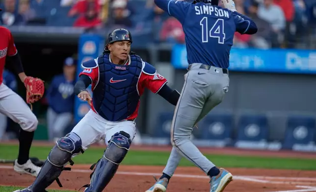 Cleveland Guardians catcher Bo Naylor, left, covers as Tampa Bay Rays' Chandler Simpson (14) attempts to run home but was called out in the first inning of a baseball game in Cleveland, Tuesday, April 28, 2026. (AP Photo/Sue Ogrocki)