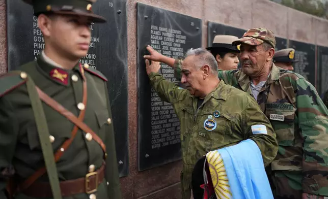 Eduardo Benitez, front, a veteran of the 1982 Falklands War, known in Argentina as the Malvinas, between Argentina and Britain, pays his respects at a monument to the fallen on the anniversary of the start of the war in Buenos Aires, Argentina, Thursday, April 2, 2026. (AP Photo/Natacha Pisarenko)