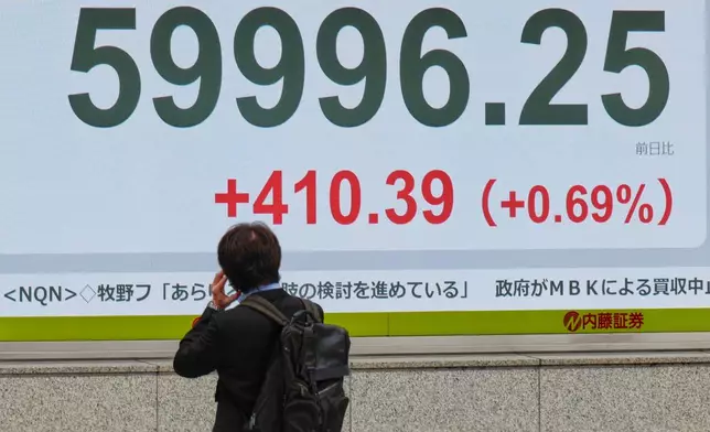 A person looks at an electronic stock board showing Japan's Nikkei index at a securities firm Thursday, April 23, 2026, in Tokyo. (AP Photo/Eugene Hoshiko)