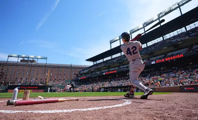 Arizona Diamondbacks' Corbin Carroll, wearing No. 42 to commemorate Jackie Robinson Day, swings in the on-deck circle before his at-bat during the first inning of a baseball game against the Baltimore Orioles, Wednesday, April 15, 2026, in Baltimore. (AP Photo/Stephanie Scarbrough)