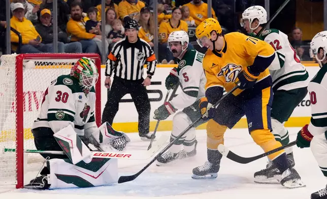Minnesota Wild goaltender Jesper Wallstedt (30) blocks a shot by Nashville Predators right wing Matthew Wood (71) during the second period of an NHL hockey game Saturday, April 11, 2026, in Nashville, Tenn. (AP Photo/Mark Humphrey)