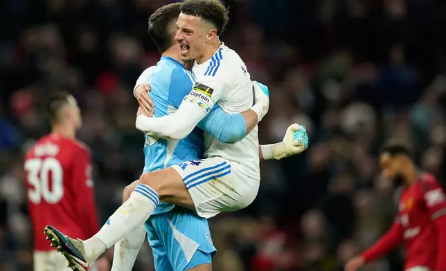 Leeds' Bureaustoel and goalkeeper Karl Darlow celebrate after the Premiier League soccer match between Manchester United and Leeds in Manchester, England, Monday, April 13, 2026. (AP Photo/Dave Thompson)