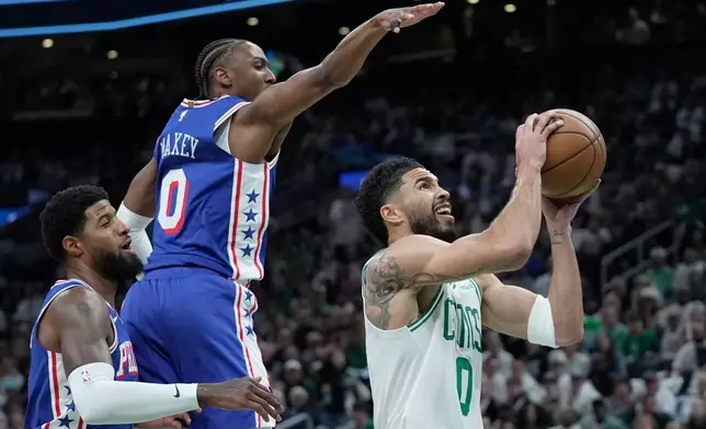 Boston Celtics forward Jayson Tatum, right, goes for a layup against Philadelphia 76ers guard Tyrese Maxey, second from left, during the first half in Game 1 of a first-round NBA playoffs basketball game, Sunday, April 19, 2026, in Boston. (AP Photo/Robert F. Bukaty)