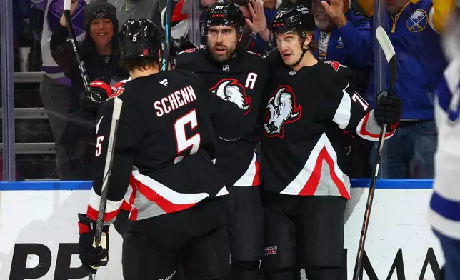 Buffalo Sabres right wing Alex Tuch, center, celebrates after his goal with defenseman Luke Schenn (5) and center Ryan McLeod (71) during the first period of an NHL hockey game against the Tampa Bay Lightning, Monday, April 6, 2026, in Buffalo, N.Y. (AP Photo/Jeffrey T. Barnes)