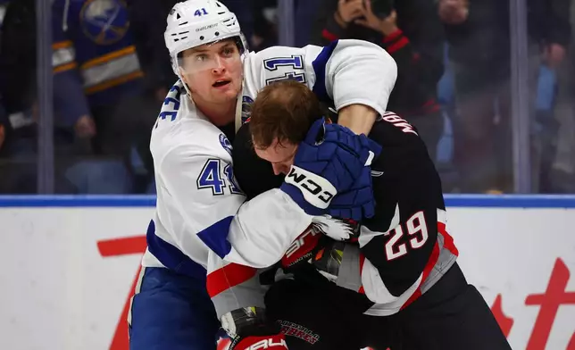 Tampa Bay Lightning right wing Mitchell Chaffee (41) grabs Buffalo Sabres left wing Beck Malenstyn (29) during the first period of an NHL hockey game Monday, April 6, 2026, in Buffalo, N.Y. (AP Photo/Jeffrey T. Barnes)