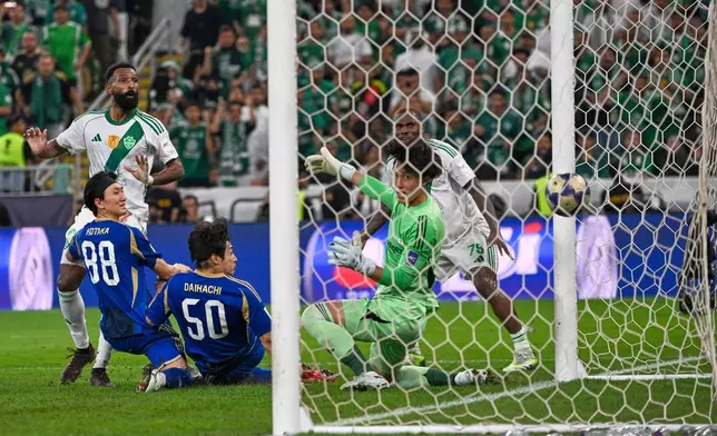 Al-Ahli's Feras Albrikan, left, scores at Machida Zelvia's goal keeper Kosei Tani, during the AFC Champions League Elite Final soccer match between Al-Ahli and Machida Zelvia at King Abdullah Sports City Stadium, in Jeddah, Saudi Arabia, Saturday, April 25, 2026. (AP Photo/Ali Issa)