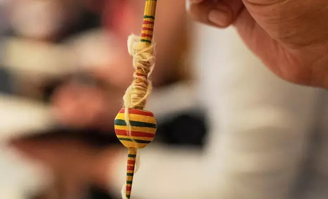 A person takes part in a backstrap loom workshop for LGBTQ+ people by Muxe artist Xaneri Merino in Mexico City, Tuesday, April 14, 2026. (AP Photo/Marco Ugarte)