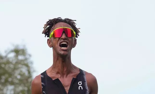 Italy's Yemaneberhan Crippa celebrates after crossing the finish line to win the men's race of the Paris marathon, in Paris, Sunday, April 12, 2026. (AP Photo/Thibault Camus)