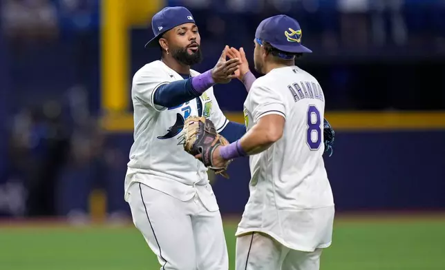 Tampa Bay Rays third baseman Junior Caminero celebrates with first baseman Jonathan Aranda (8) after the team defeated the New York Yankees during a baseball game Friday, April 10, 2026, in St. Petersburg, Fla. (AP Photo/Chris O'Meara)