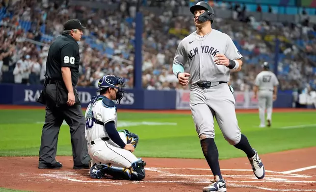New York Yankees' Aaron Judge, right, scores on a sacrifice fly by Cody Bellinger off Tampa Bay Rays pitcher Steven Matz during the first inning of a baseball game Friday, April 10, 2026, in St. Petersburg, Fla. (AP Photo/Chris O'Meara)