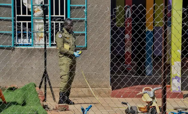 A security personnel secures the crime scene after a man killed four children in a machete attack at the Gaba Early Childhood Development Program nursery school in Kampala, Uganda, Thursday, April 2, 2026. (AP Photo)