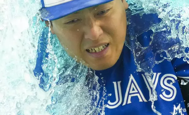Toronto Blue Jays third baseman Kazuma Okamoto gets doused by teammates after their 5-3 win over the Cleveland Guardians in a baseball game in Toronto, Saturday, April 25, 2026. (Chris Young/The Canadian Press via AP)