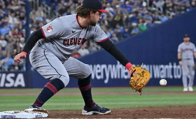 Cleveland Guardians first baseman Rhys Hoskins takes a throw from shortstop Juan Brito to put out Toronto Blue Jays' Daulton Varsho in third-inning baseball game action in Toronto, Sunday, April 26, 2026. (Jon Blacker/The Canadian Press via AP)