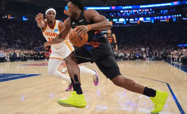 New York Knicks' OG Anunoby, right, drives past Atlanta Hawks' Onyeka Okongwu during the first half in Game 5 of a first-round NBA playoffs basketball series, Tuesday, April 28, 2026, in New York. (AP Photo/Frank Franklin II)