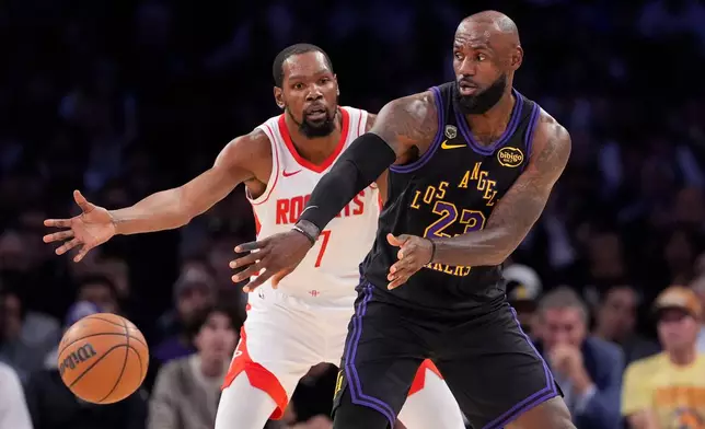 Los Angeles Lakers forward LeBron James, right, passes the ball while under pressure from Houston Rockets forward Kevin Durant during the first half in Game 2 of a first-round NBA playoffs basketball series Tuesday, April 21, 2026, in Los Angeles. (AP Photo/Mark J. Terrill)