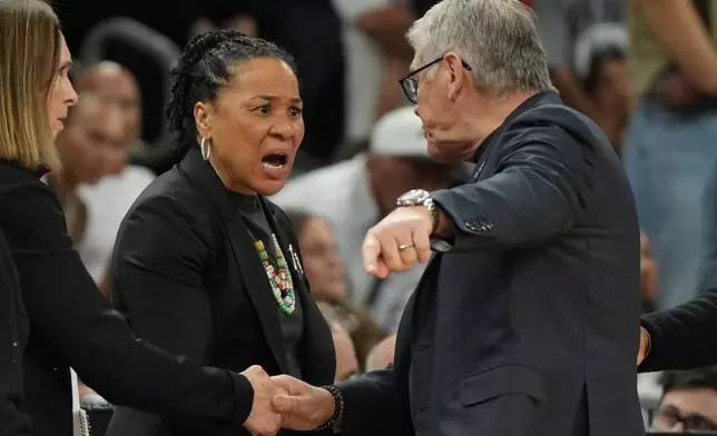 South Carolina head coach Dawn Staley, center, and UConn head coach Geno Auriemma argue after a woman's NCAA college basketball tournament semifinal game at the Final Four, Friday, April 3, 2026, in Phoenix. (AP Photo/Rick Scuteri)