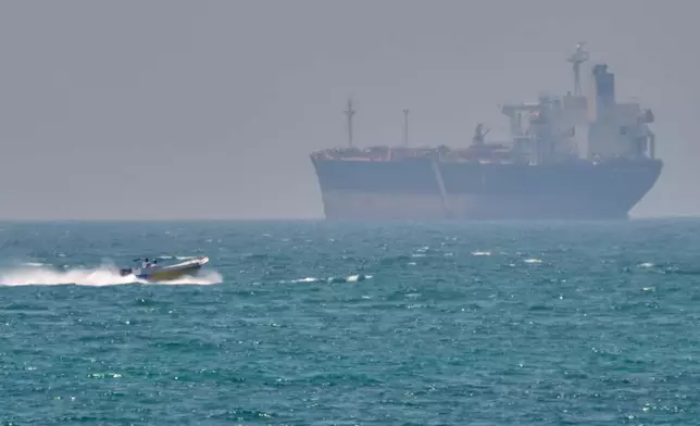 FILE - A boat sails past a tanker anchored on the Strait of Hormuz off the coast Qeshm island, Iran, April 18, 2026. (AP Photo/Asghar Besharati, File)