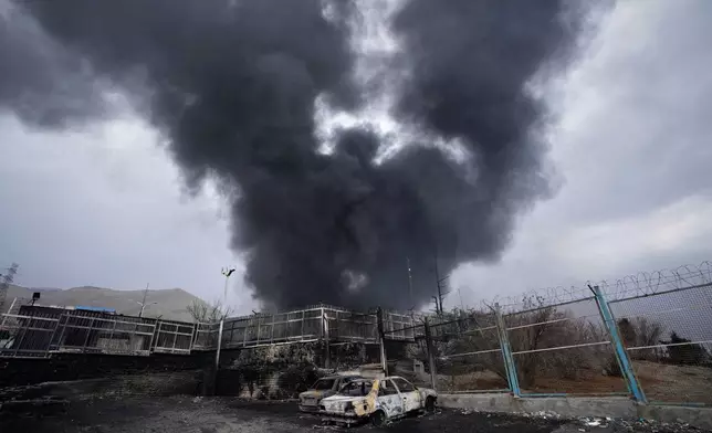 FILE - A thick plume of smoke rises from an oil storage facility hit by a U.S.-Israeli strike in Tehran, Iran, March 8, 2026. (AP Photo/Vahid Salemi, File)